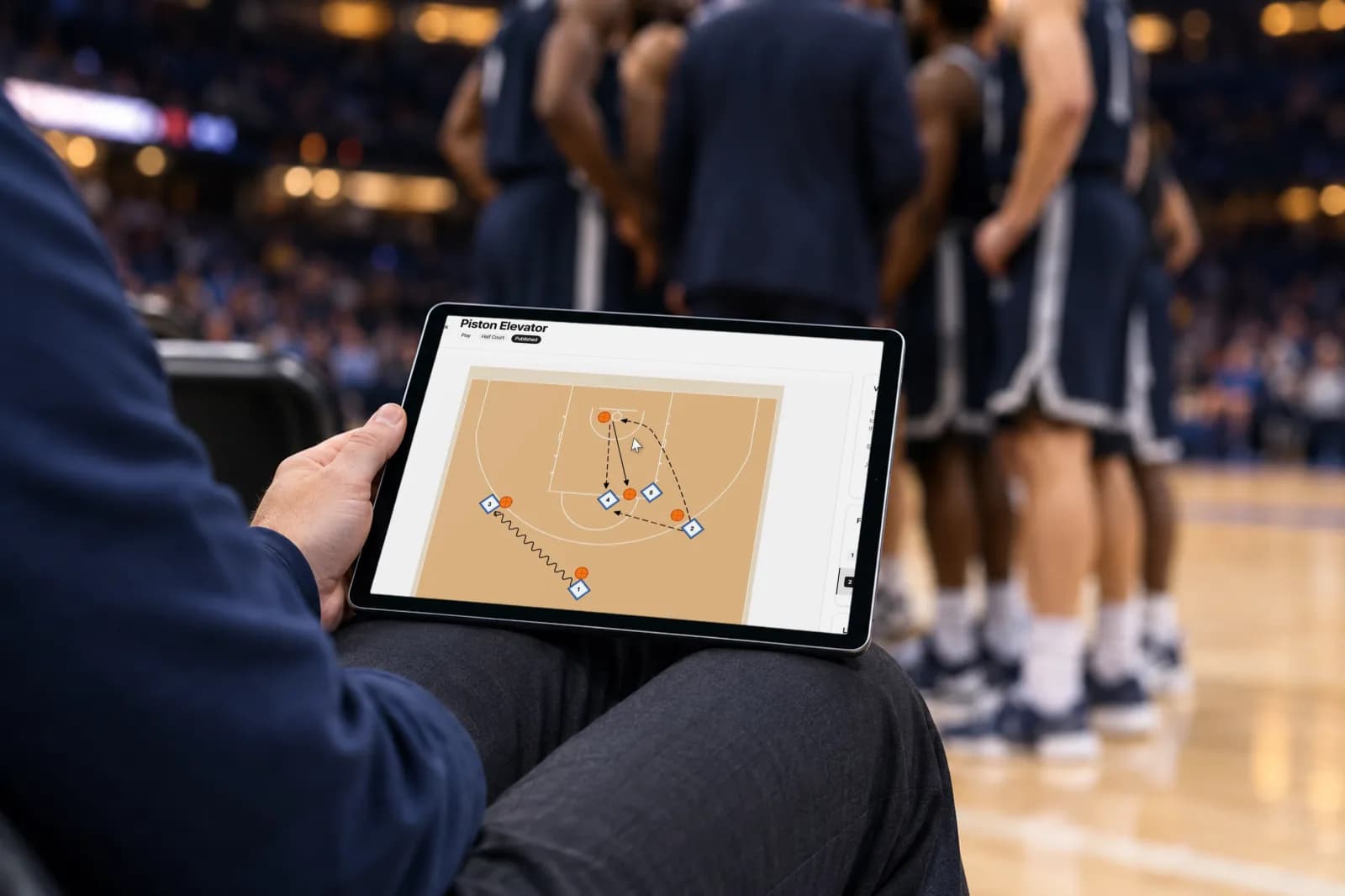 Pizarra táctica de baloncesto de SpotBasket en un iPad a pie de pista con una jugada animada en media pista