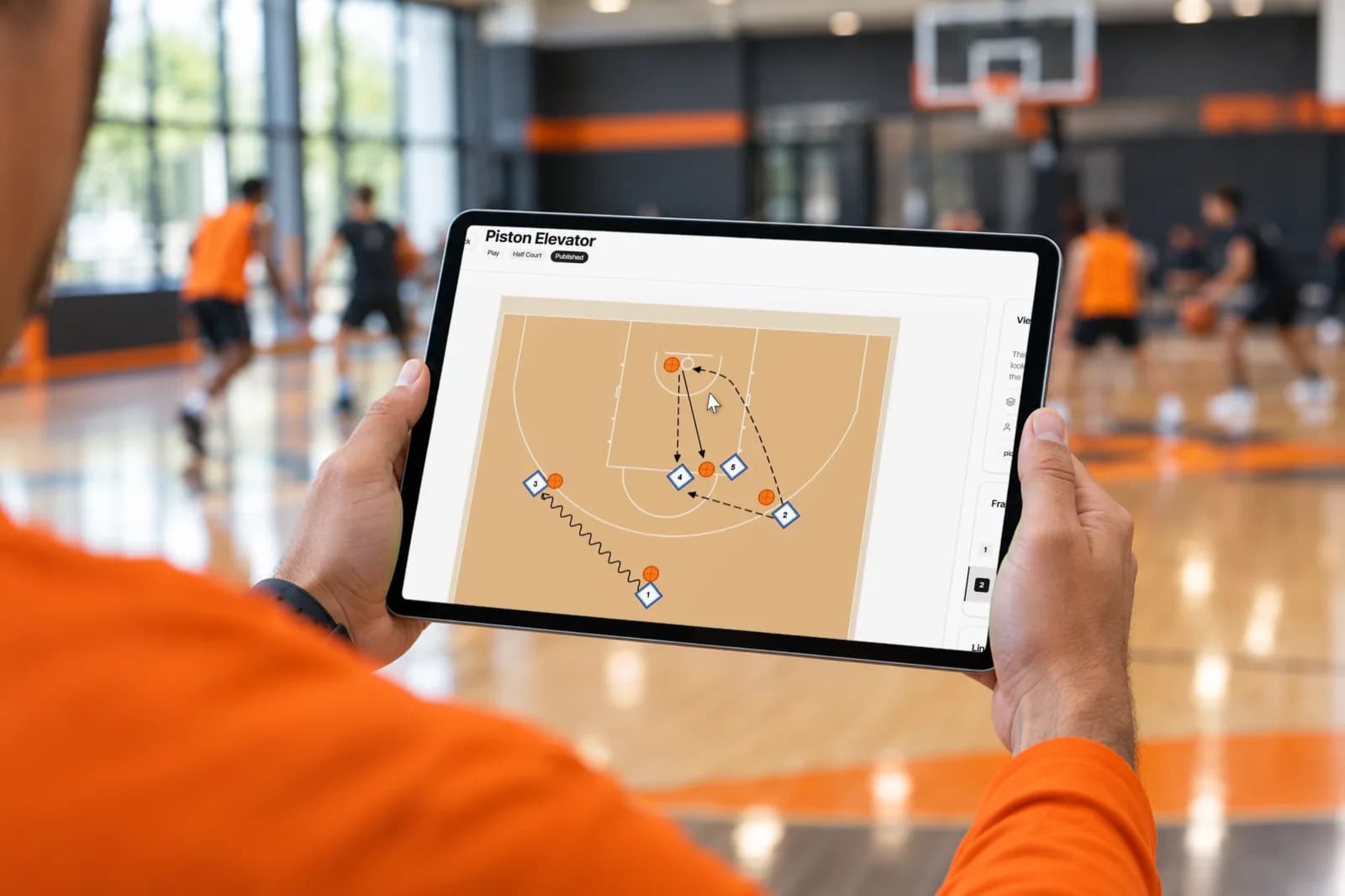 Pizarra táctica de baloncesto de SpotBasket en un iPad a pie de pista con una jugada animada en media pista