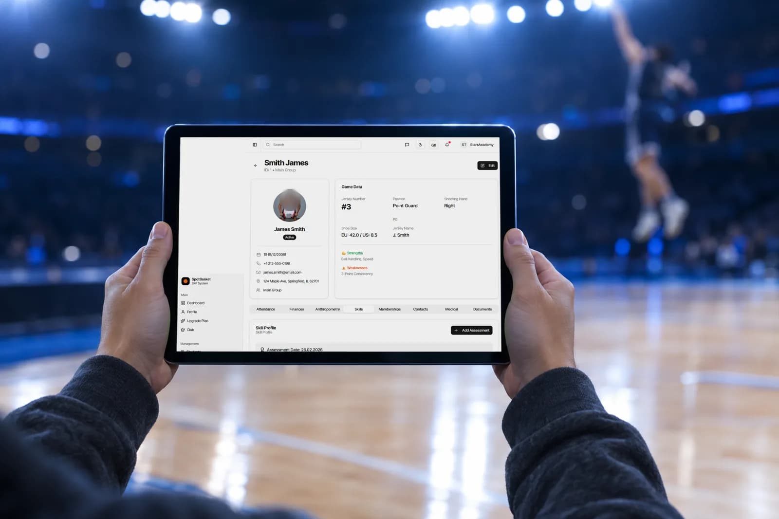 Entrenador rellenando una evaluación de jugadores de baloncesto en una tablet durante unas pruebas